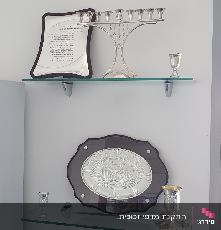 מדפי זכוכית עם חנוכייה וגביעים